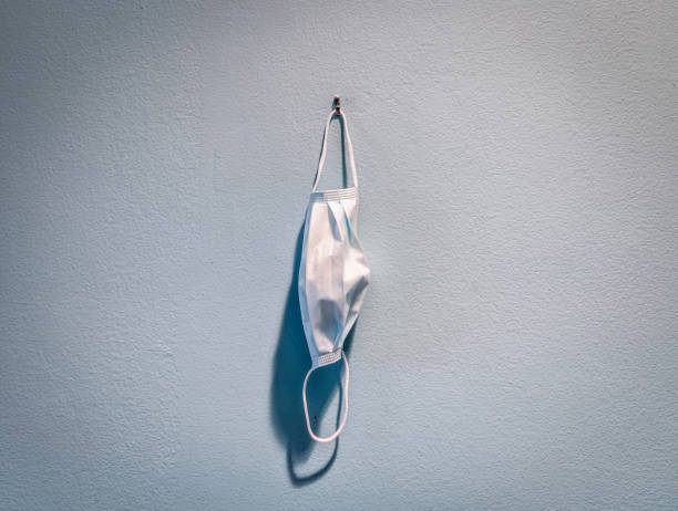 istock Still-life of a disposable protective mask hanging on a wall. 1284577383