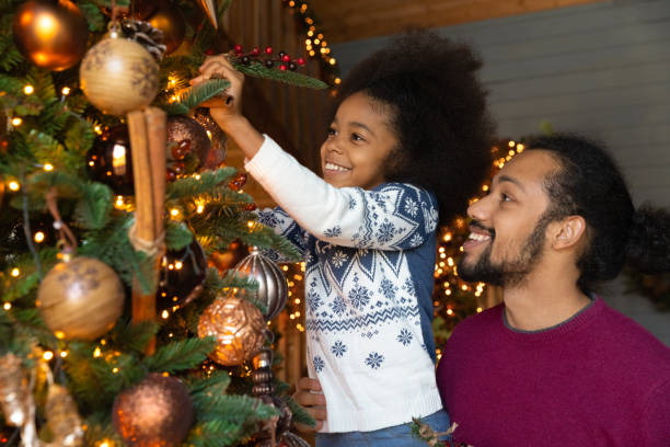 istock Close up African American father with daughter decorating Christmas tree 1284578733