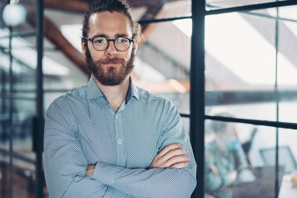 istock Young businessman standing with arms crossed 1284579802