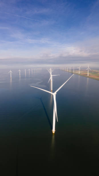 istock offshore windmill park with clouds and a blue sky, windmill park in the ocean drone aerial view with wind turbine 1284580713
