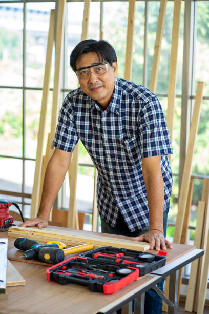 istock professional Asian Engineer with protective hard hat safety work in workshop wood plank construction site.   work from home new normal concept. 1284580778