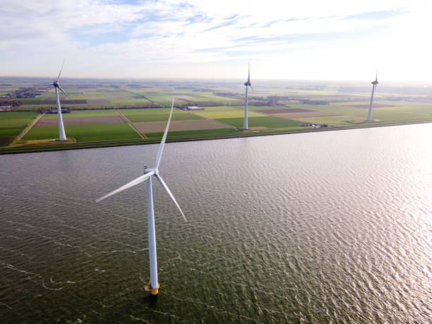 istock offshore windmill park with clouds and a blue sky, windmill park in the ocean drone aerial view with wind turbine 1284580926