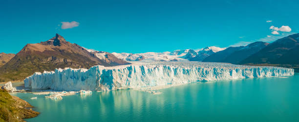 istock Panoramic view over gigantic Perito Moreno glacier in Patagonia with blue sky and turquoise water glacial lagoon, South America, Argentina, at sunny day.. 1284581957