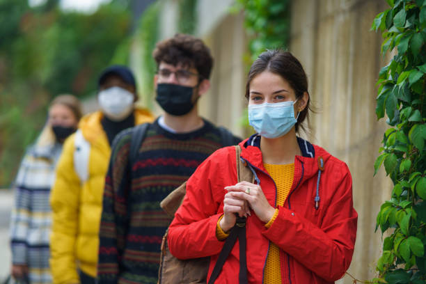 istock Young people standing outdoors in town. Coronavirus and safe distance concept. 1284581996