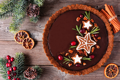 Christmas chocolate gingerbread pie. Top down view table scene over a dark wood background. Holiday baking concept.