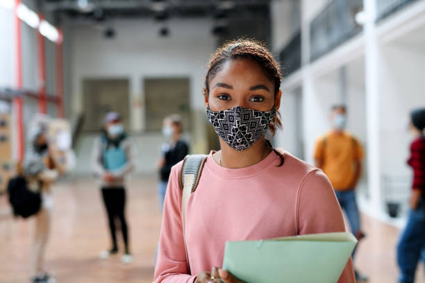 afroamerikanische studentin mit gesichtsmaske zurück an der hochschule oder universität, coronavirus-konzept. - universitätsstudent fotos stock-fotos und bilder