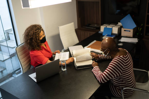 istock Architect showing some fabric swatch to a customer - using face mask 1284585866