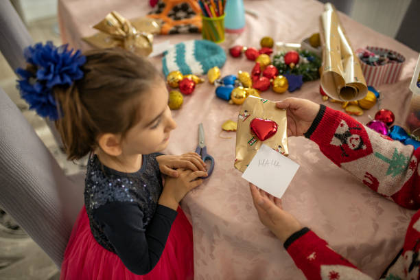 istock Grandma and grandchild together time while wrapping Christmas presents 1284585871