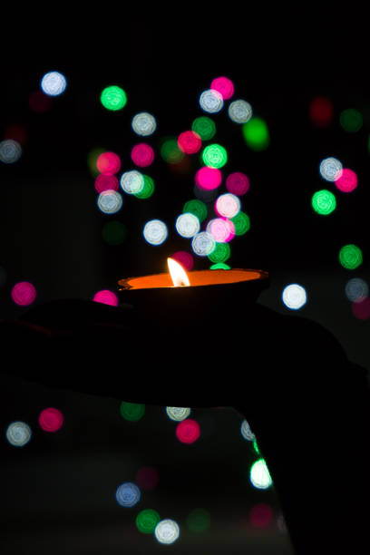 istock Diwali Diya (oil lamp) in hands with bokeh background. 1284587204