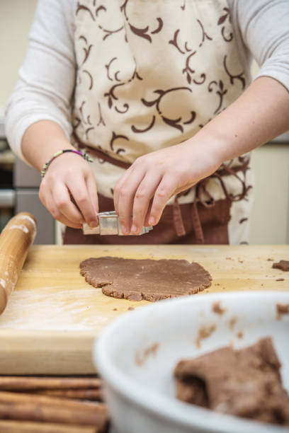 istock Hands of Teenage Girl Making Biscuits using Cookie Molds 1284587293