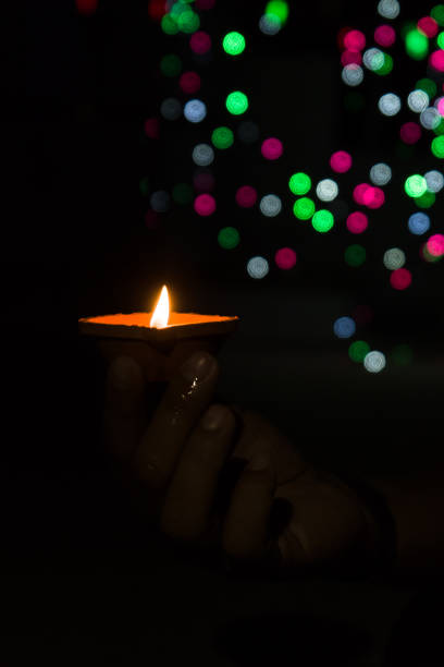 istock Diwali Diya (oil lamp) in hands with bokeh background. 1284587429