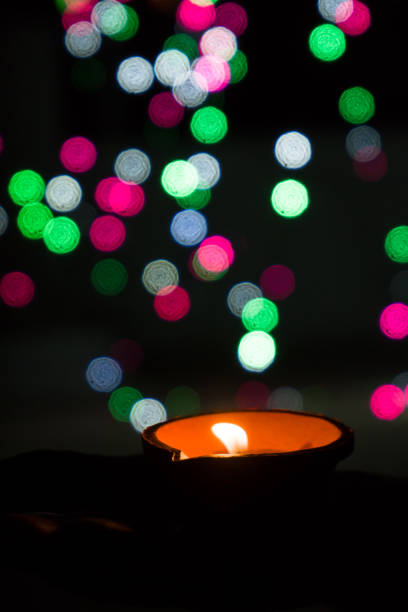 istock Diwali Diya (oil lamp) in hands with bokeh background. 1284587440