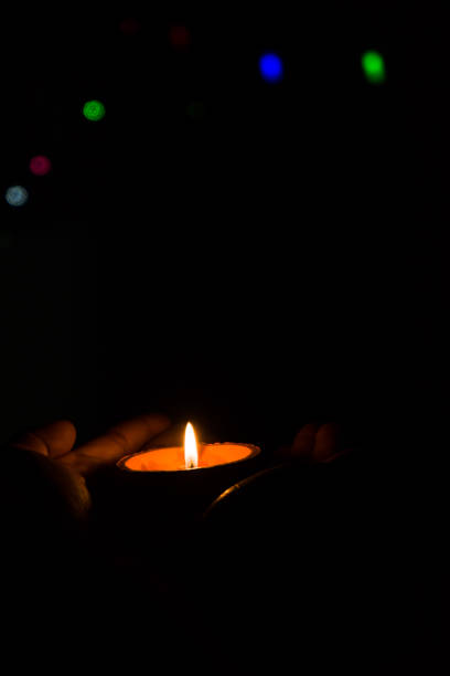 istock Diwali Diya (oil lamp) in hands with bokeh background. 1284587548
