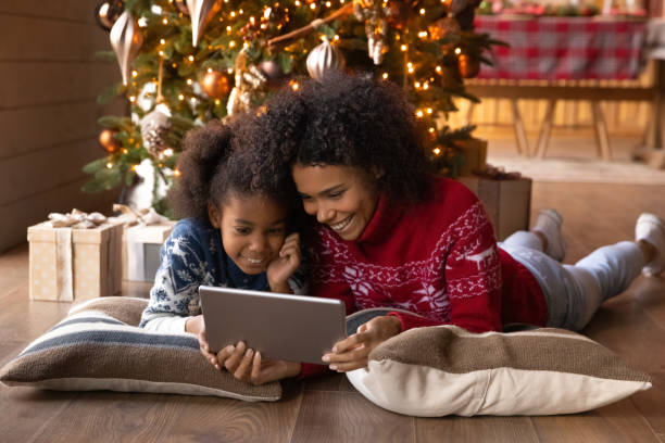 lächelnde afroamerikanische frau mit tochter mit tablet, weihnachten feiern - christmas shopping internet family stock-fotos und bilder