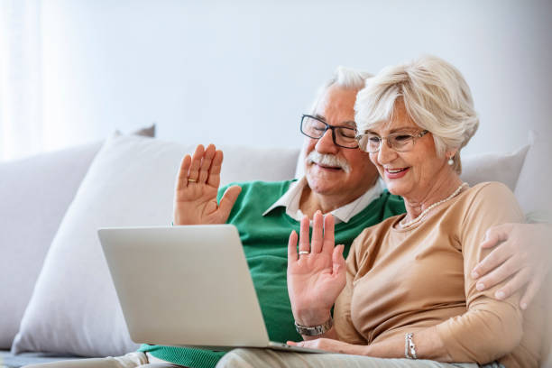 istock Side view of senior Caucasian couple interacting with each other while using laptop at retirement home 1284590156