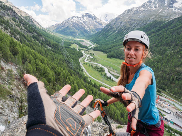 istock Climber helping teammate with a helping hand 1284591725