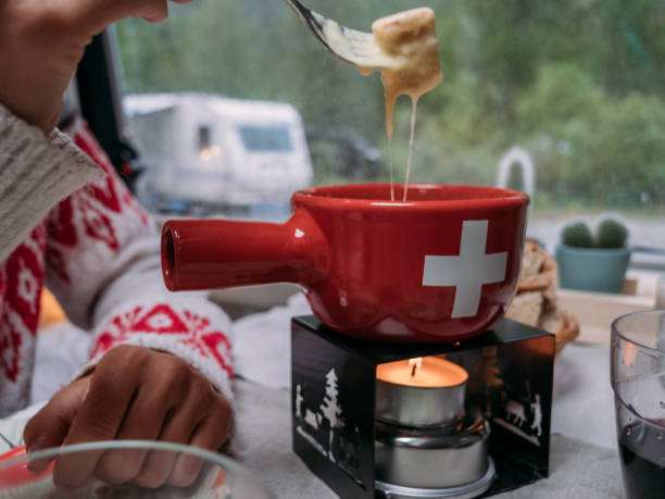 крупным планом на женщину едят сыр фондю - fondue swiss culture winter cheese стоковые фото и изображения