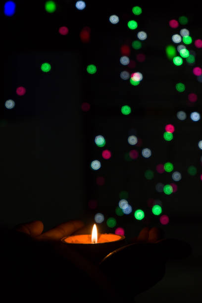 istock Diwali Diya (oil lamp) in hands with bokeh background. 1284592892