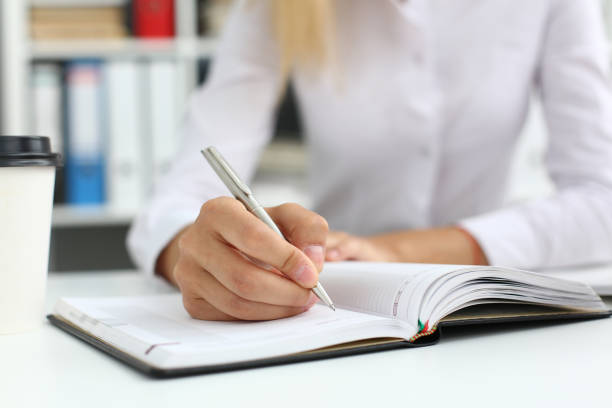 istock Businesswoman jotting down working information in sketchbook 1284594280