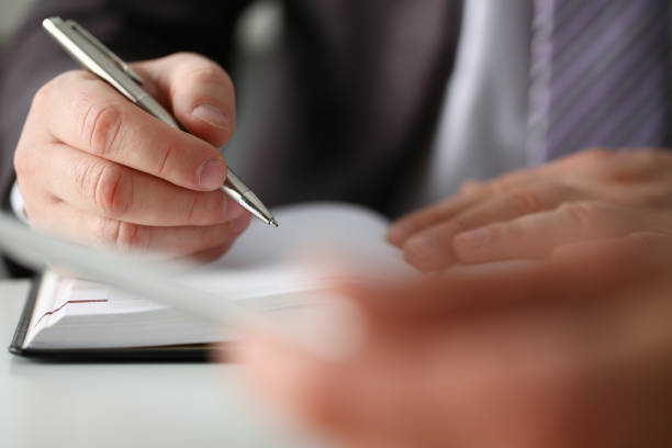 istock Businessman in suit signing papers in office 1284594340