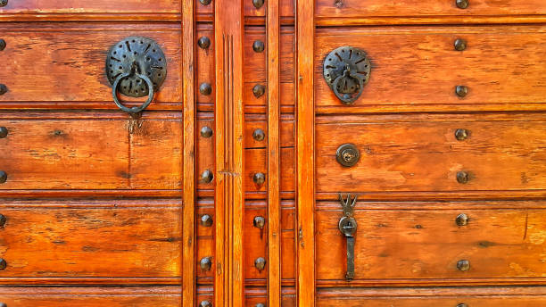 istock Historic polished wooden door with iron door knobs 1284595729