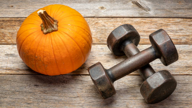 istock dumbbells on rustic wood with pumpkin 1284595845