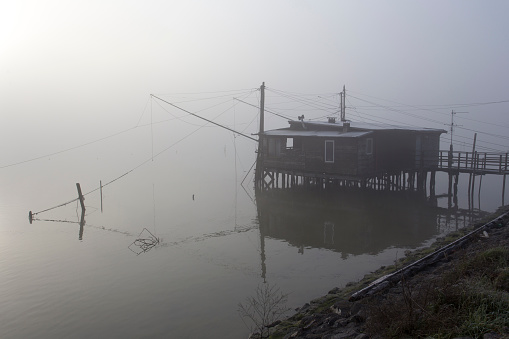 Comacchio, Italy - December 29, 2019: view of fishing house in Comacchio, foggy day