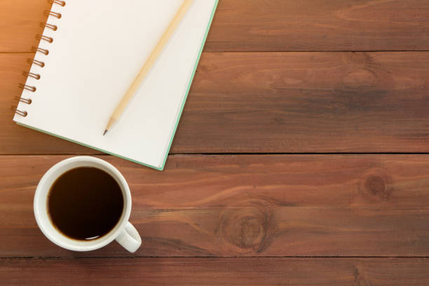 istock Coffee served in a cup, placed beside a pencil and note book 1284599934