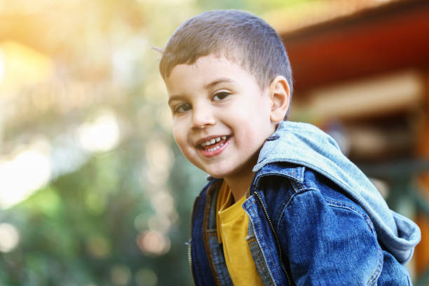 istock Happy little boy looking at camera and smiling with blurred background 1284602495