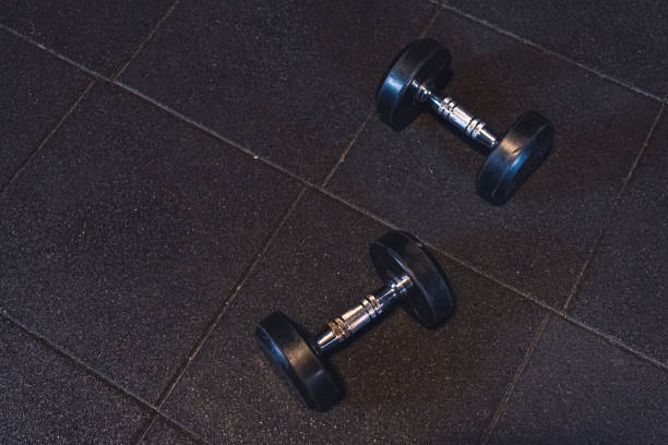 istock two iron dumbbells in gym gary background workout 1284604794
