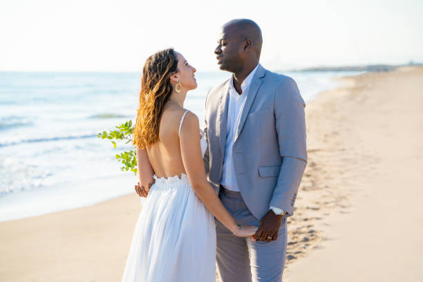 casal de casamento de mãos dadas na praia em lua de mel - honeymoon wedding beach couple - fotografias e filmes do acervo