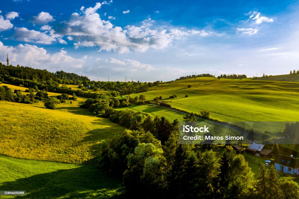 drone shoot agricultural field grass small village Aerial View Stock Photo
