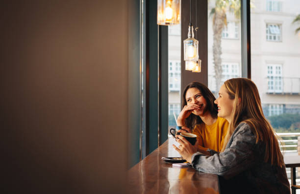 istock Two women sitting at a cafe and smiling 1284605103