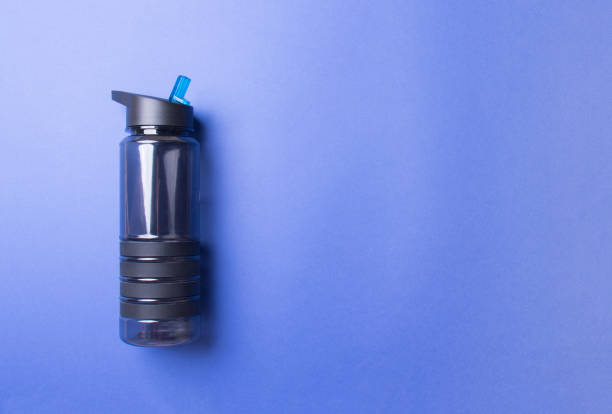 istock black plastic sport bottle lying on left side of blue background with copy space 1284605176