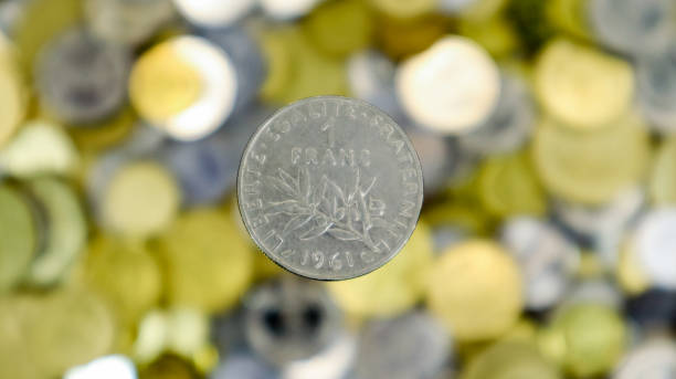 un primo primo ministro mostra una moneta da 1 franco francese del 1961. questi sono soldi. sfondo di denaro sfocato. tipo di seminatore. menta - parigi. realizzato in nichel - french coin foto e immagini stock