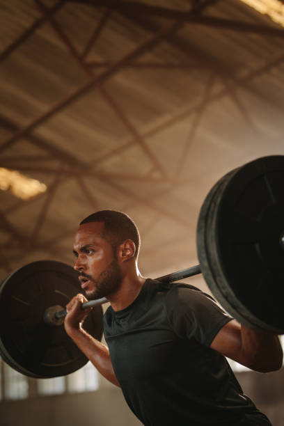 istock Man doing squats with barbell in gym 1284607354