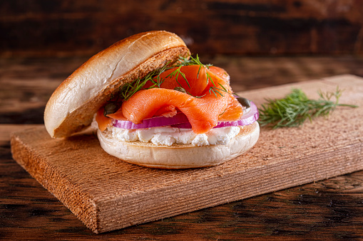 A delicious toasted plain bagel with smoked salmon, cream cheese, red onion, capers and dill.