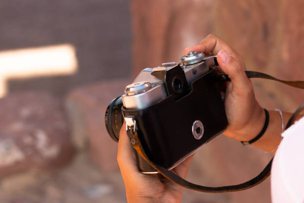istock Close-up of a young woman's hands holding an old analog camera 1284608640