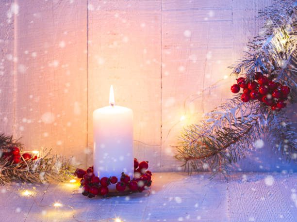 istock Fir branches, candle and  Christmas decorations on the old  wooden table. Focus on  candle flame 1284608672