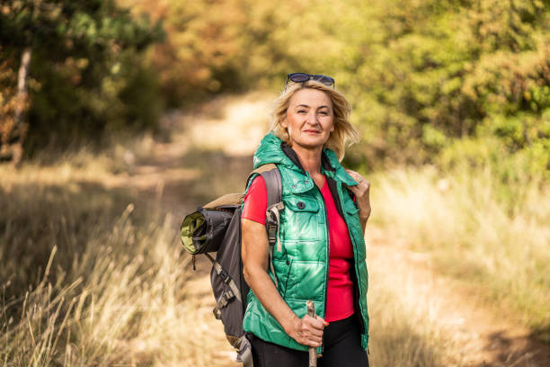istock Senior woman with backpack hiking on sunny day 1284610427