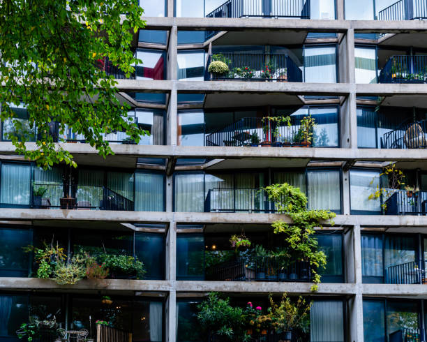 Lush plants and bushes growing on the balconies of the residents of this grey building at the Haarlemmer Houttuinen