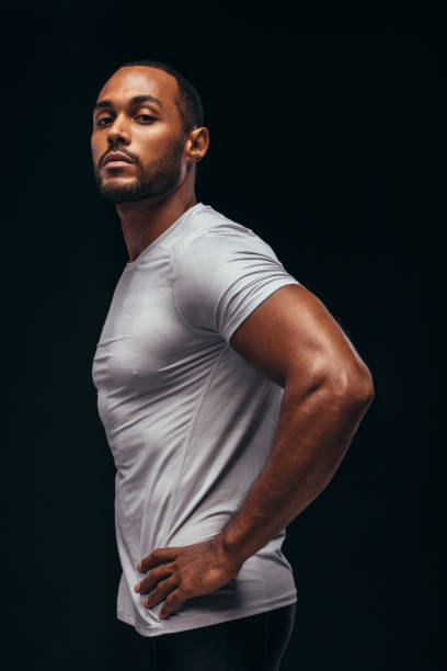 istock Side view portrait of a fit man on black background 1284613196