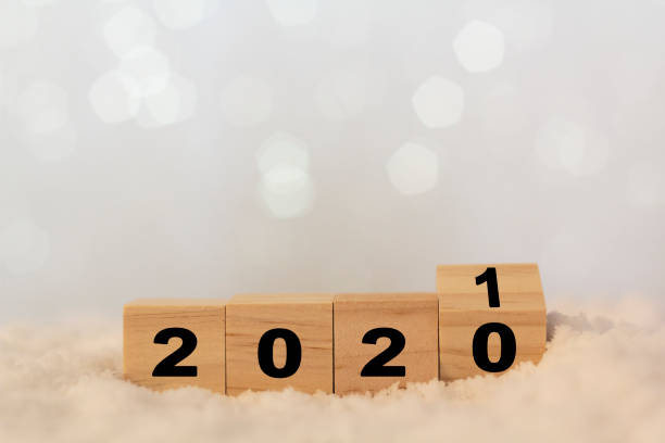 2020年の新年は、雪が降るテーブルの上で2021年に変更されます。コピースペース付き木製キューブ - turning list ストックフォトと画像