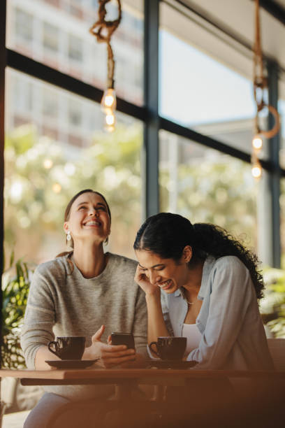 istock Female friends smiling in a cafe 1284615342