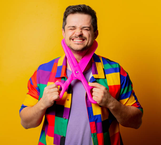 istock guy in 90s shirt with big scissors on yellow background 1284619098