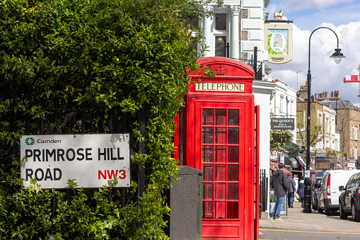 Primrose Hill Road in Borough of Camden, London, with people and car number plates visible in the background as well as a red telephone box