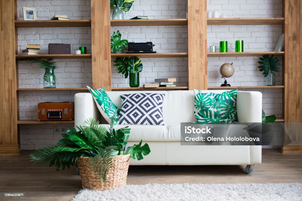 Stylish room interior with white sofa and tropical leaves Home Decor Stock Photo