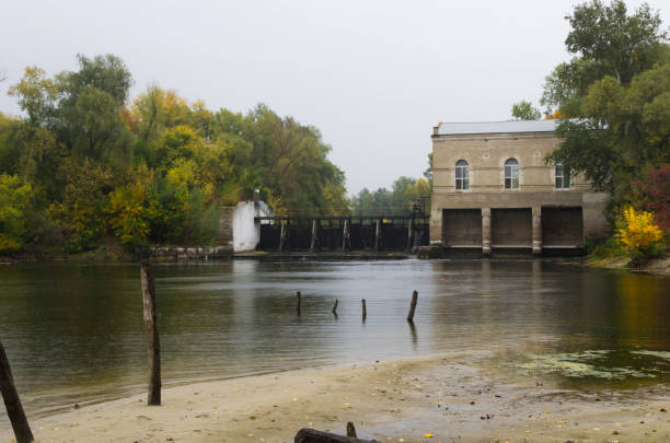 old hydroelectric power station on a small river in autumn cloudy weather - miniature weir imagens e fotografias de stock