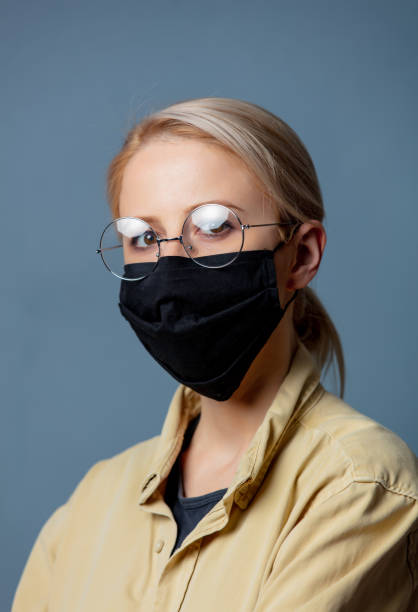 istock Woman in black face mask on grey background 1284623072