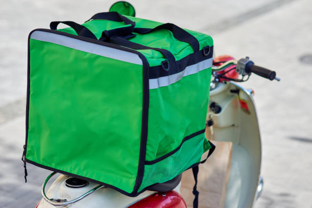 istock Green thermo backpack with food and drinks on scooter standing outdoors 1284623184